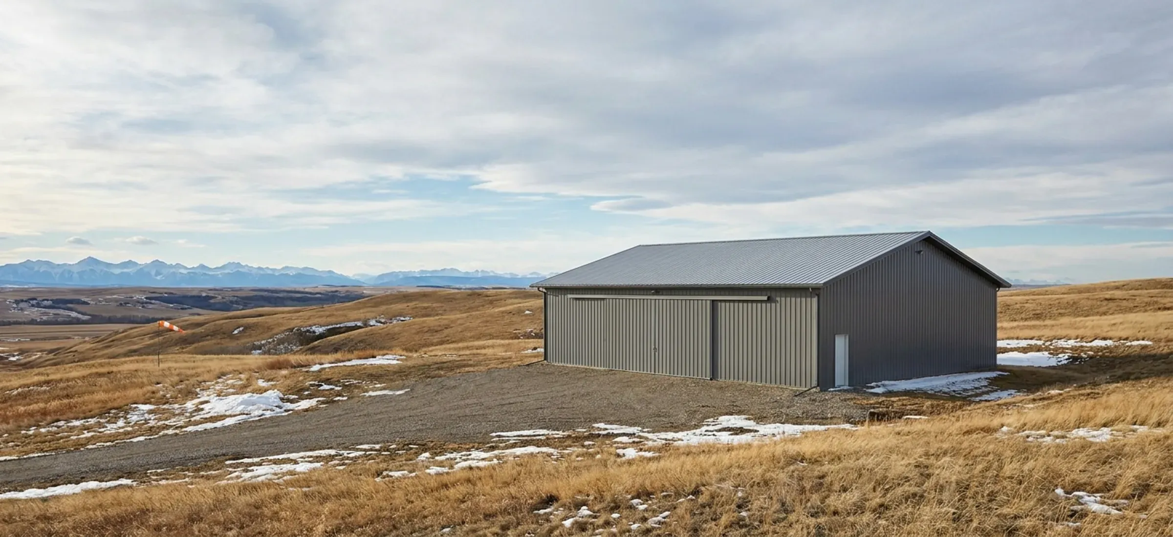 A steel shop with a low roofline on a ridge-top acreage with a wide mountain view