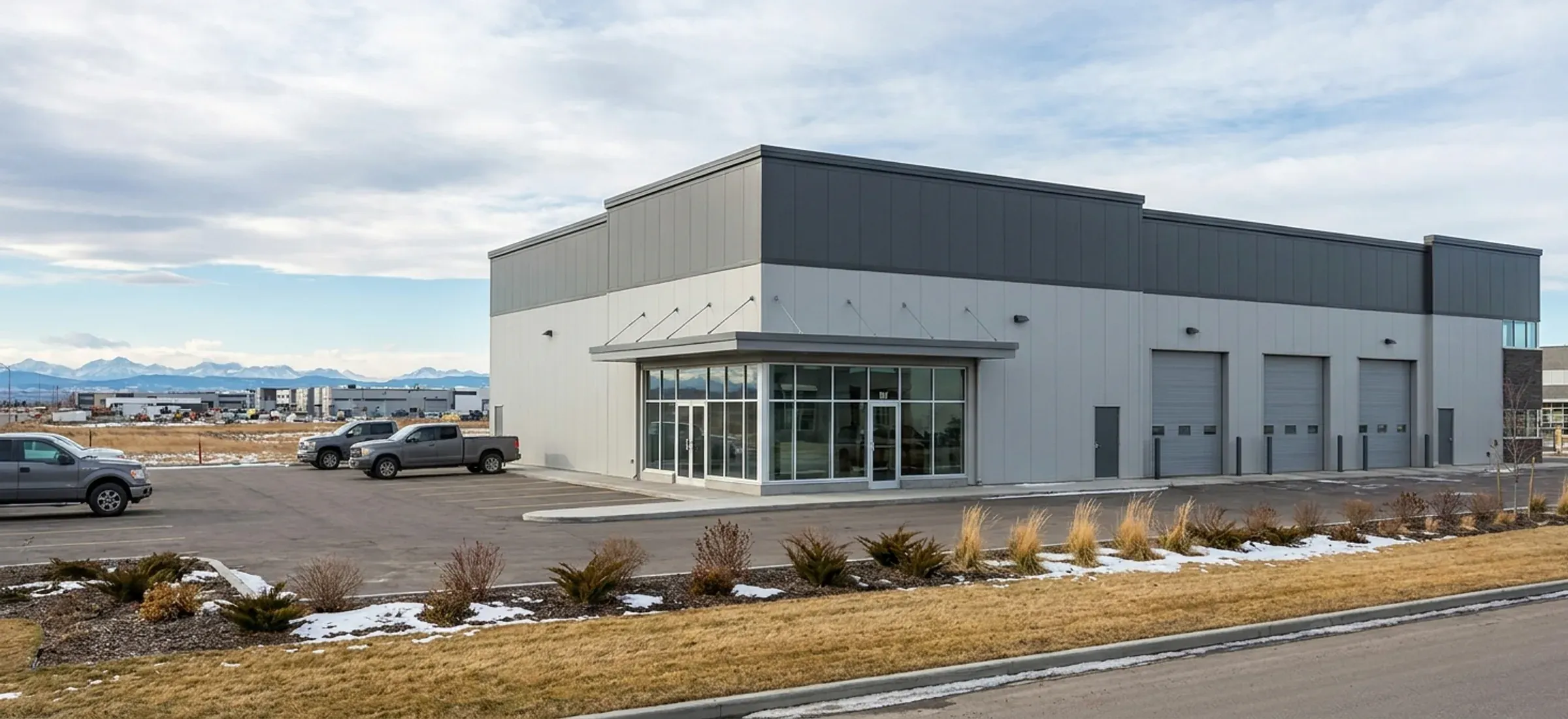 A two-tone steel commercial building with a showroom front and service bays in a city industrial park