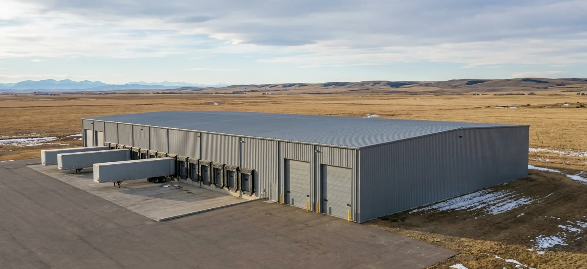 A very large 100 by 200 foot clear-span steel building with dock doors and a truck court